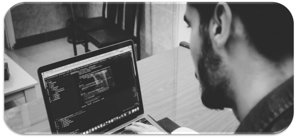 Photographie en noir et blanc d'un développeur opérationnel codant un programme
