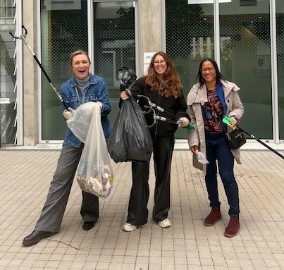3 personnes avec des sacs poubelle et des dans pour la clean walk