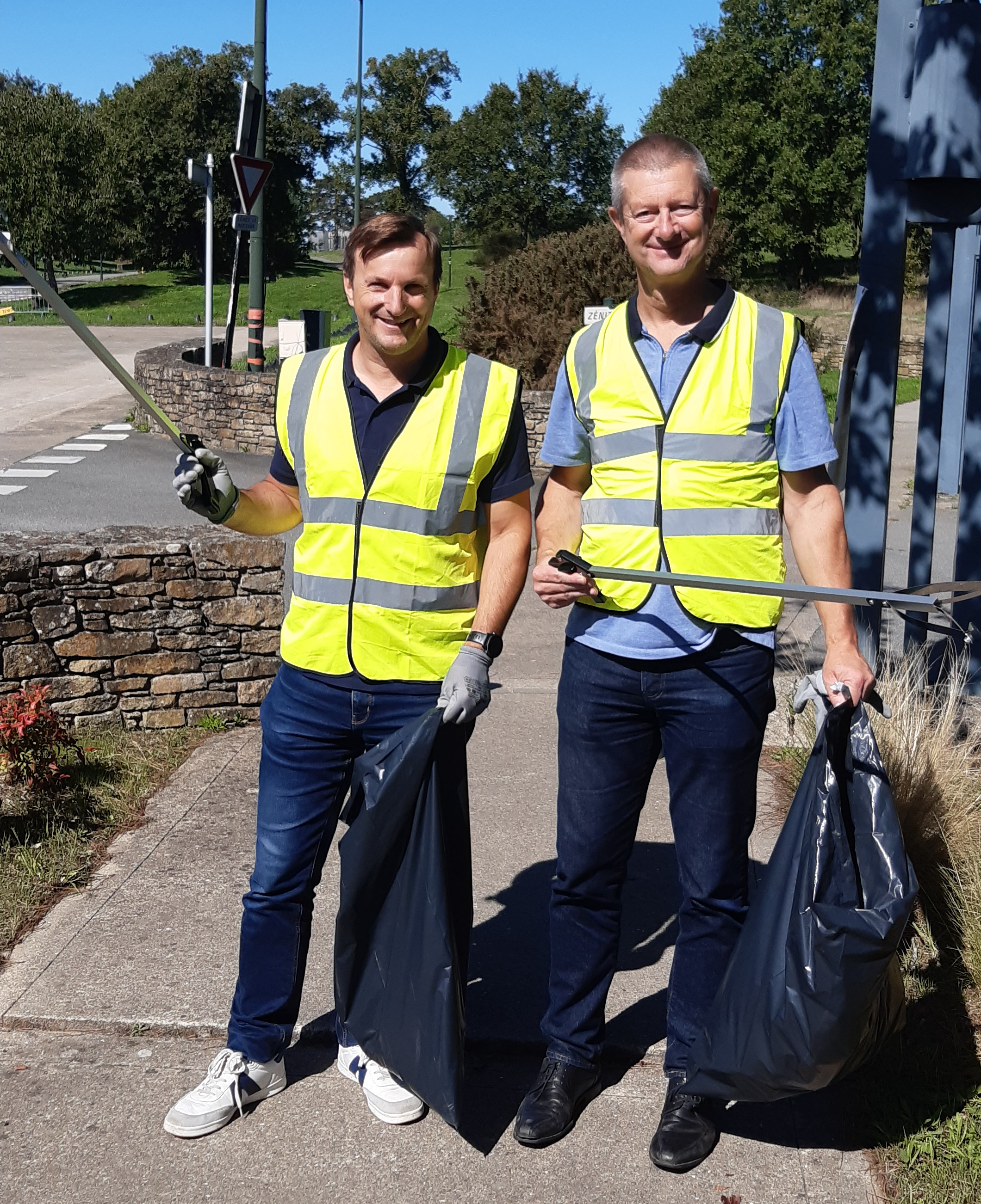 2 personnes avec des sacs poubelle et des dans pour la clean walk